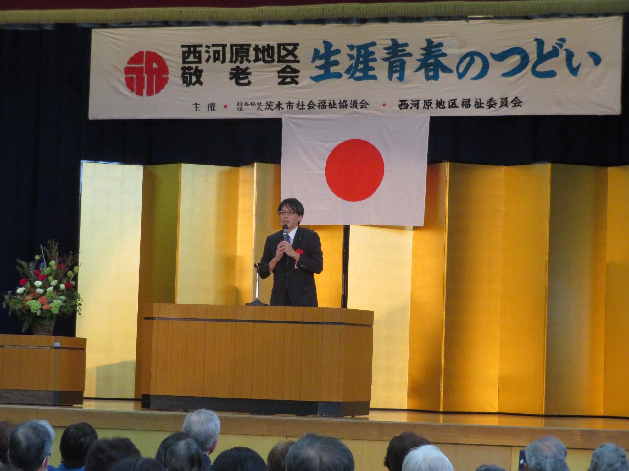 舞台上であいさつをする市長の写真