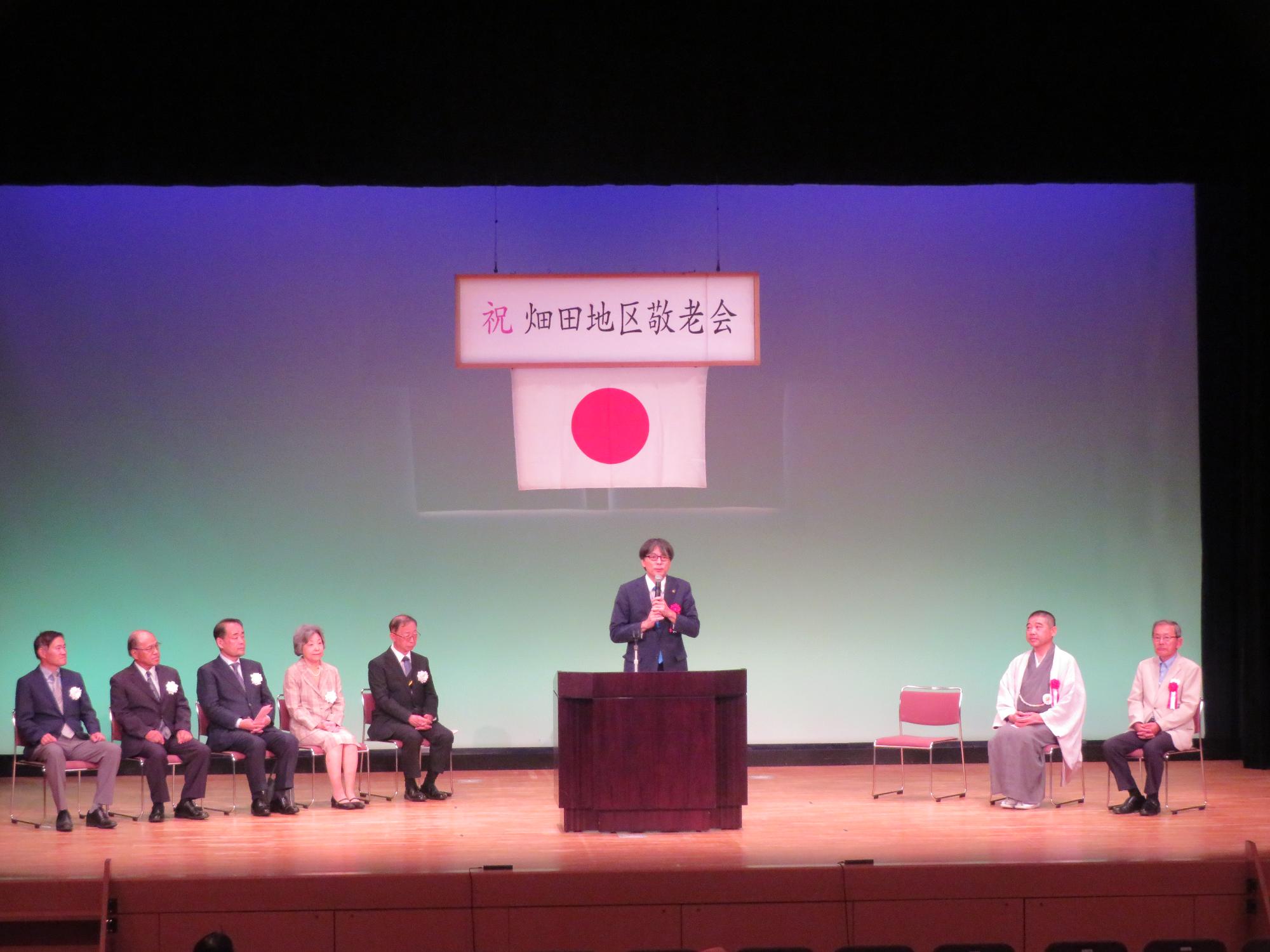 舞台上であいさつをする市長の写真