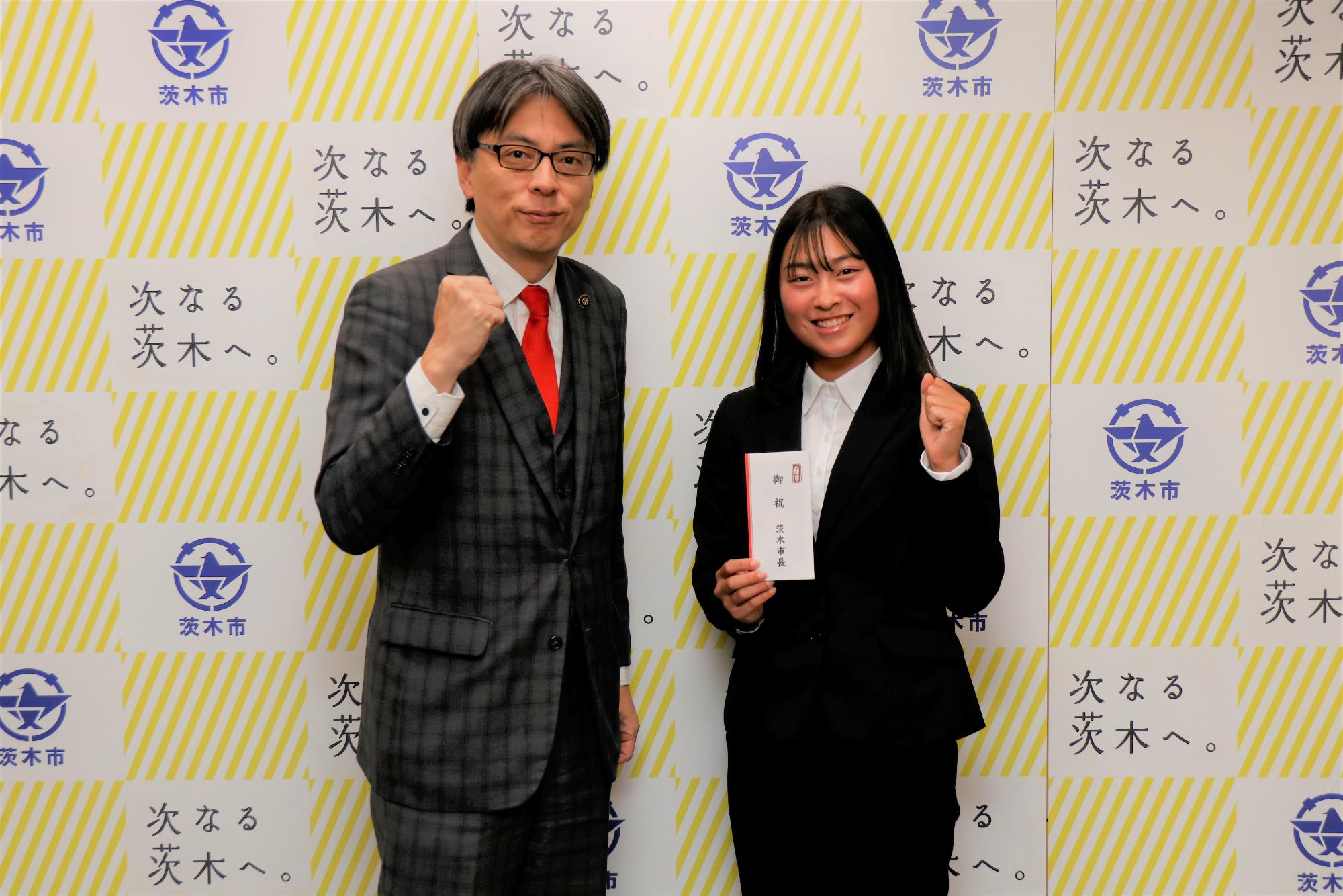 ガッツポーズをする選手と市長の写真