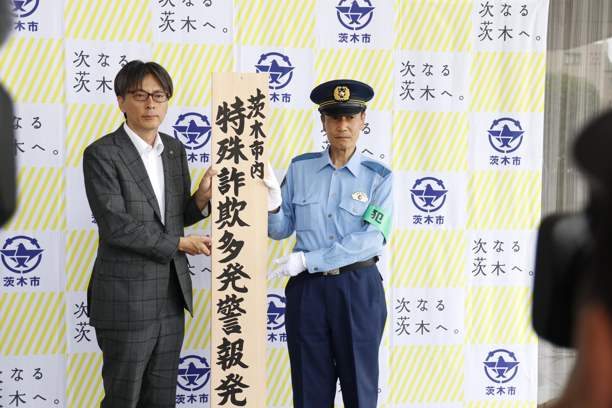 茨木警察署長と茨木市特殊詐欺多発警報発令の看板を持つ市長の写真