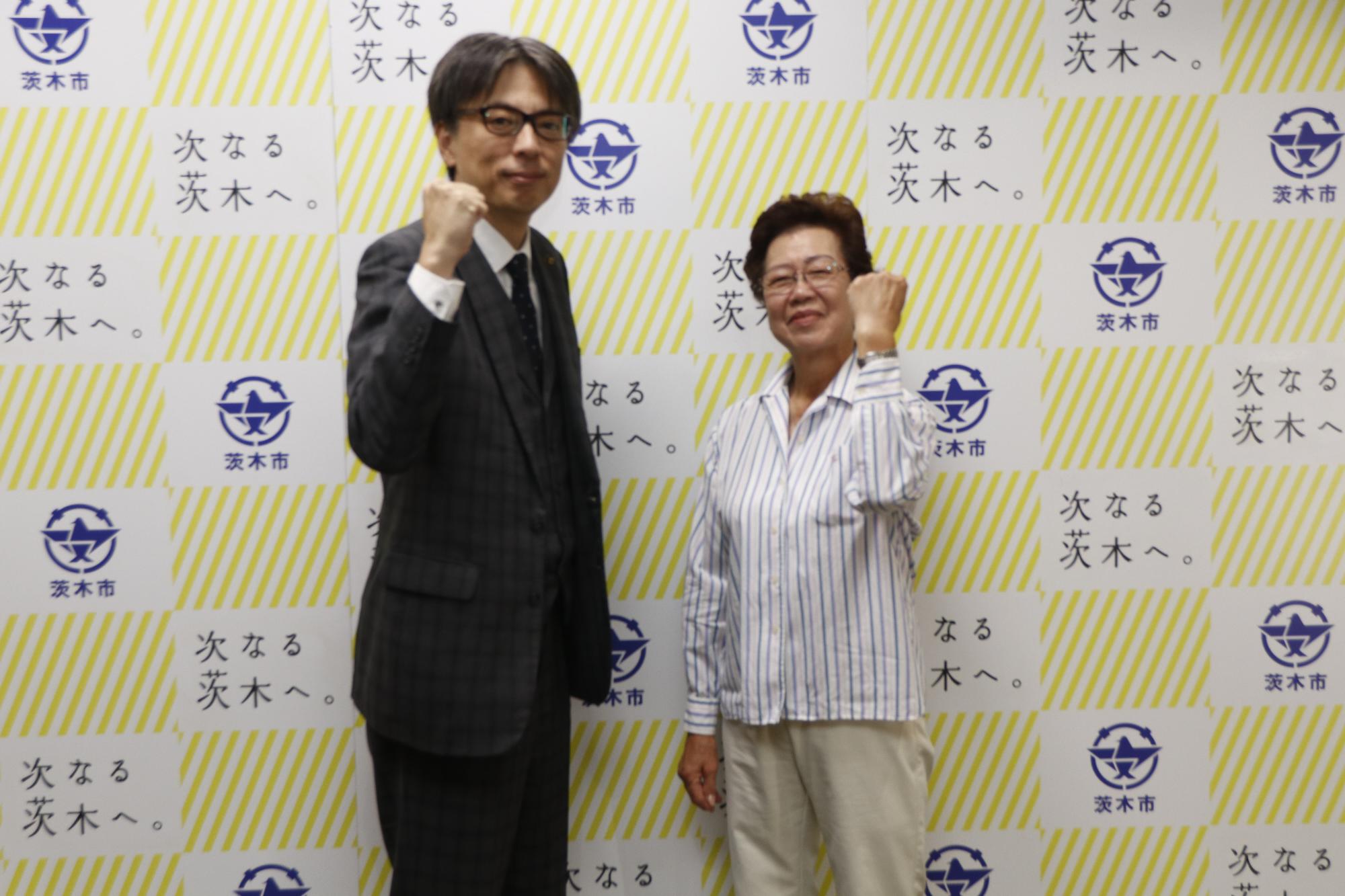 吉井由美子さんとガッツポーズをする市長の写真