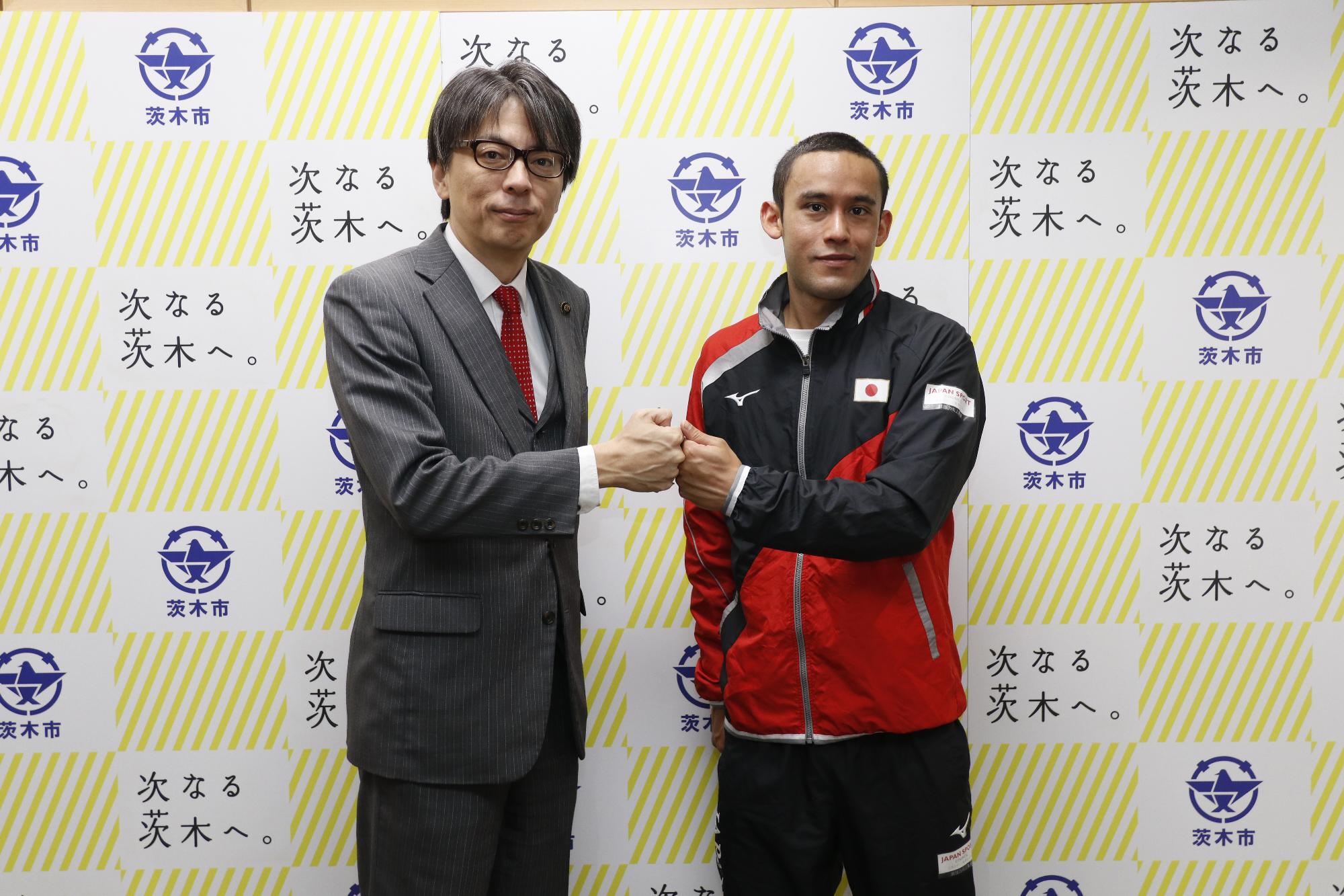 グータッチをする関ケビンさんと市長の写真