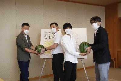 すいかを持つ障害福祉サービス事業所の方と佐竹食品株式会社梅原社長と市長の写真