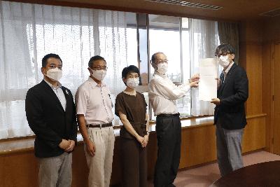 茨木市監査委員の皆様から決算・基金運用状況審査意見書を受領する市長の写真