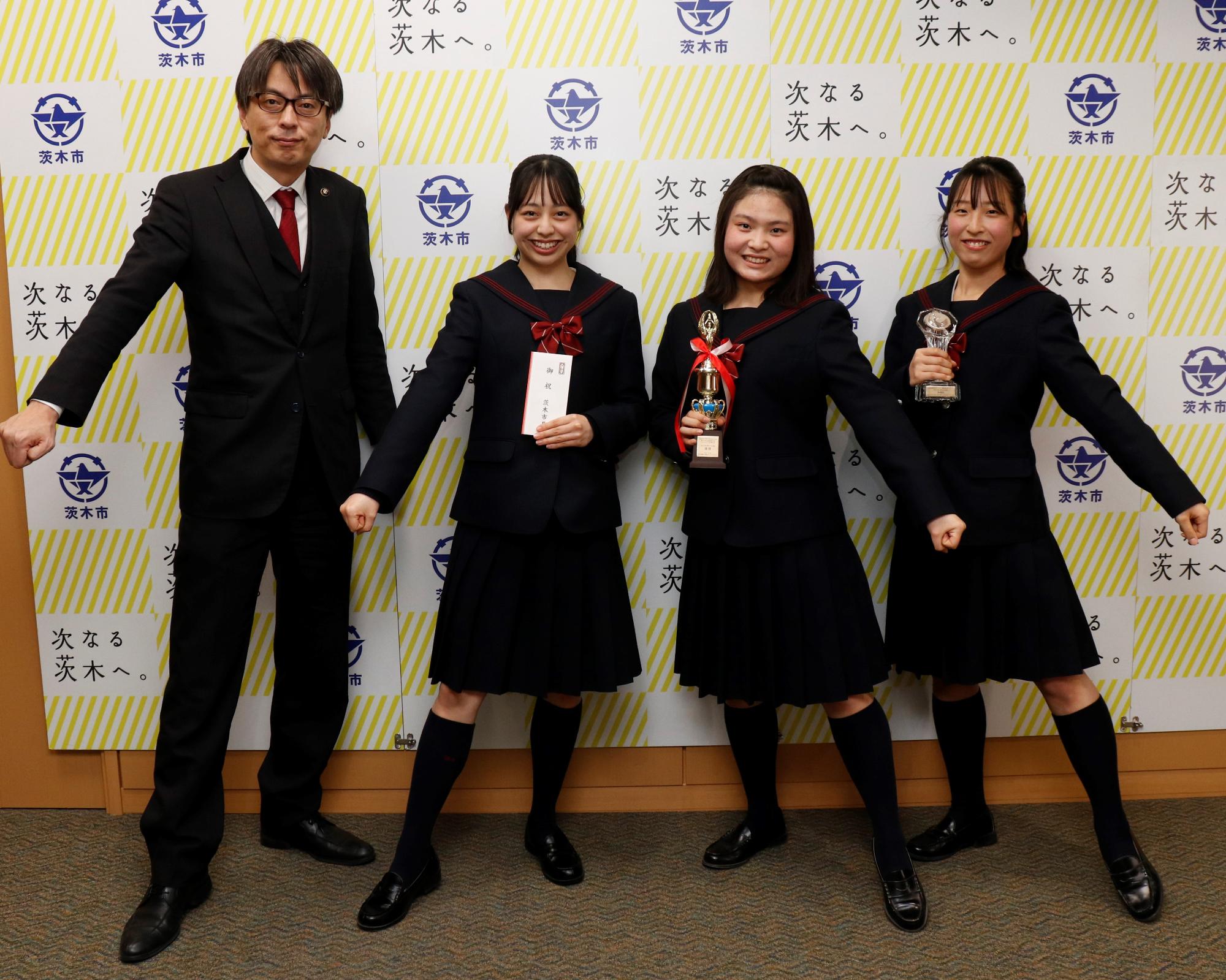 早稲田摂陵高校の生徒たちと一緒にチアダンスのポーズをする市長の写真