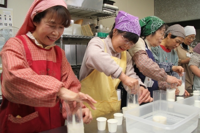参加者達が豆腐作りに挑戦している様子を撮影した画像