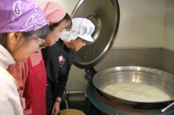 参加者達が鍋の中を覗き込んでいる様子を撮影した画像