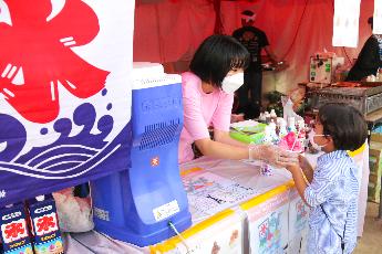 屋台でかき氷を手渡す様子