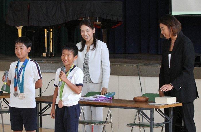 元オリンピック選手の巽さんと吉田さんからオリンピックメダルをかけてもらった児童たち