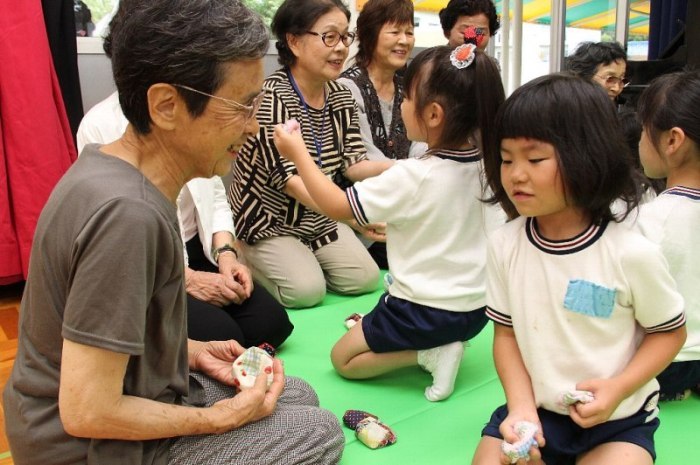 おばあちゃんと児童がお手玉をしている様子を撮影した画像