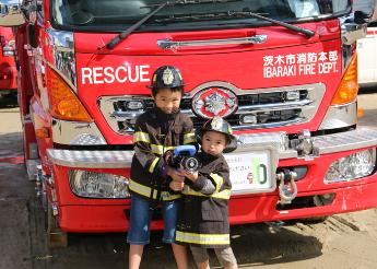 消防車の前でポーズをとる子ども