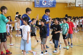 福井小学校の児童と選手がハイタッチをしている様子