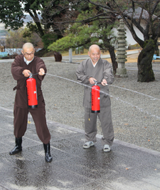 2人の真龍寺職員が消火器を使い初期消火訓練を行っている写真