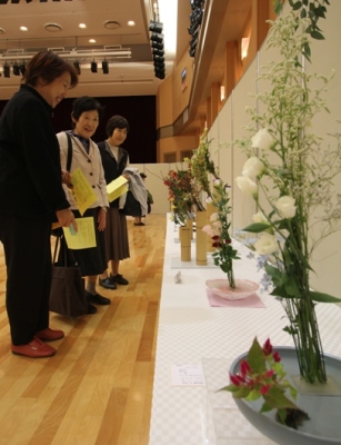 生涯センターきらめきで作品の花々を見る市民達の写真