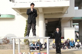 茨木工科高校の生徒が朝礼台に立ちあいさつしている写真