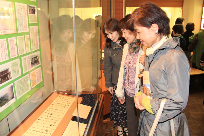 京都が舞台の川端文学についての展示を見る見学者たちを撮影した画像