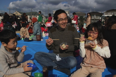 つきたての餅を食べる親子の写真