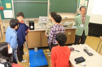 跳び箱の踏切り板で震度を測定する児童らの写真