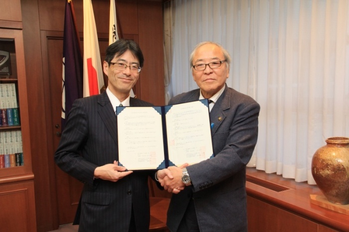 締結書を持って握手する木本市長と蔵原JR西日本京都支社長