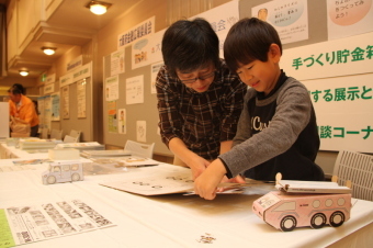 消防車型の貯金箱を作る小学生の画像