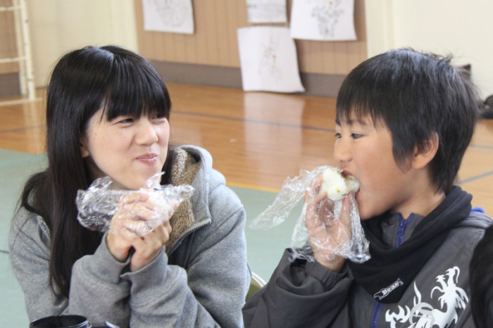 おにぎりを食べる児童と保護者