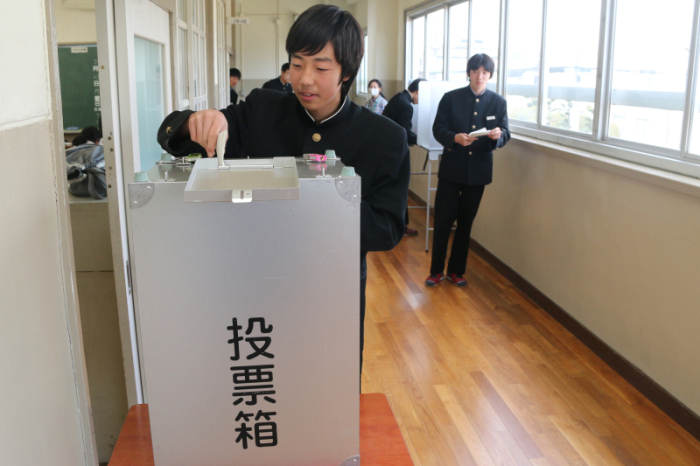 廊下に設置された投票箱に投票する生徒の写真
