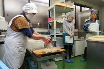 参加者が焼き豆腐の作り方を教わっている様子の写真