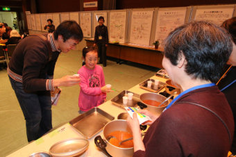 だしの味比べをする親子の写真