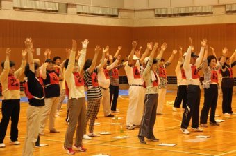 大会の前にラジオ体操をする参加者達の画像