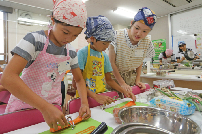 茨木高校の生徒から料理を教わる小学生の画像