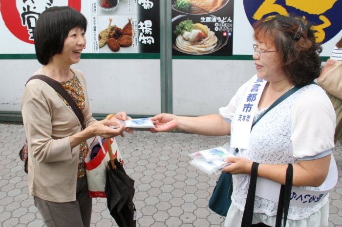 非核平和街頭キャンペーンでグッズを受け取る市民の写真