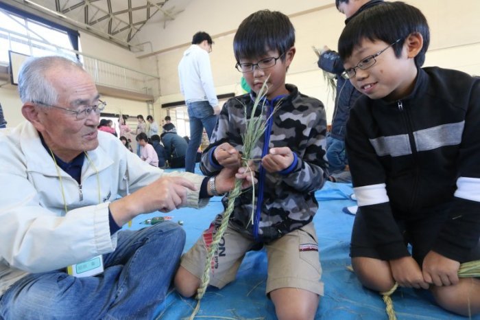 しめ縄の作り方を教わる児童たち