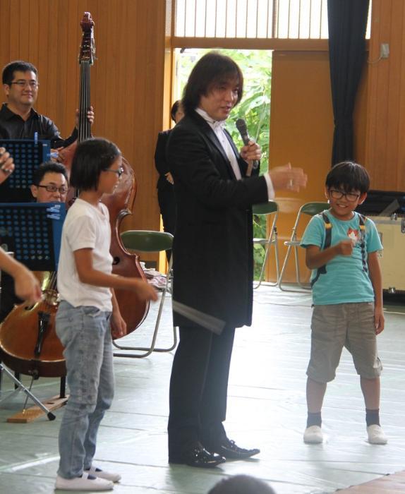 指揮の指導をする日本センチュリー交響楽団の指揮者・飯森範親さんと児童たち
