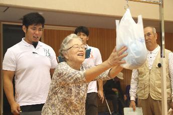 体力測定をする高齢者と見守る関西大学生