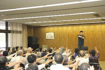 高齢者に健康体操を指導する関西大学の弘原海剛（わだつみつよし）教授