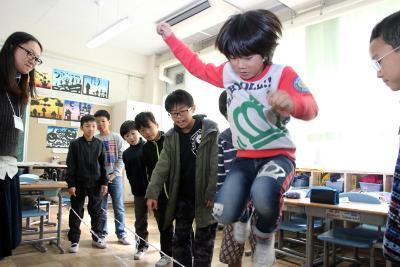 授業で、中国式のひも遊びをする児童
