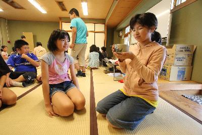 友達がたてたお茶を飲む女子児童