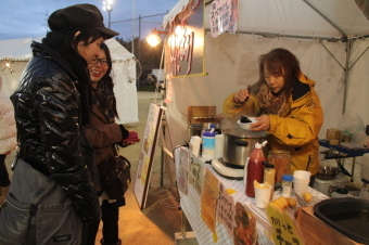 クリスマス市の露店で買い物を楽しむ市民の写真