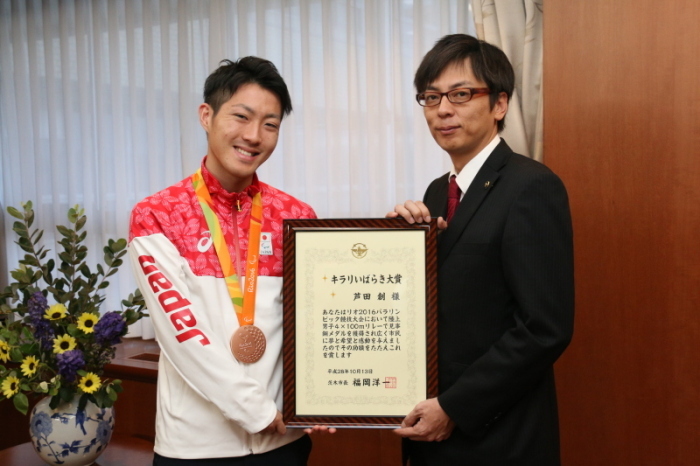 市長室で受賞したキラリいばらき大賞の額入り表彰状を持った茨木市市長と銅メダルを首に掛けた芦田選手の画像
