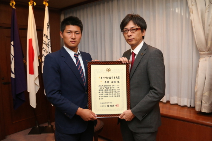 市長室で受賞したキラリいばらき大賞の額入り表彰状を持った茨木市市長と寺島選手の画像
