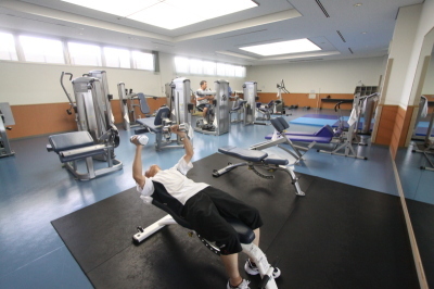 複数台のトレーニングマシンが並び複数の男性がトレーニングをする南市民体育館トレーニング室の様子